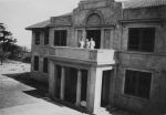 Long shot of three people standing on a balcony of the hospital. Entrance to Hospital, Circa 1940
