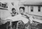 Long shot of a nurse with two patients, one patient is on an orthopaedic trolley. Patients on Trolley, Circa 1940